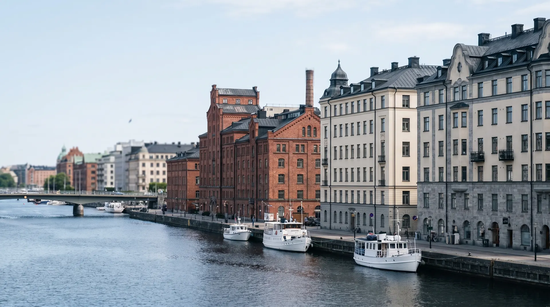 Historiska byggnader och båtar längs Stockholms vattenkant vid dagsljus.